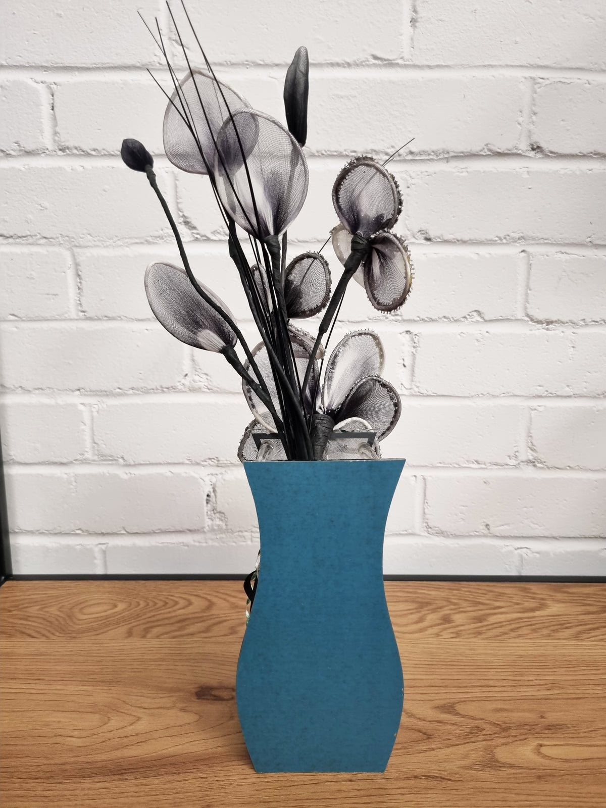 reverse of the black nylong flower display in a vase showing a blue reverse to the vase