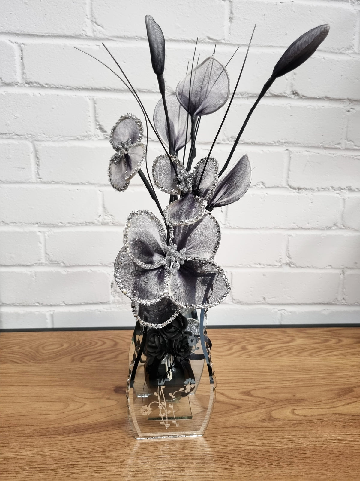 black nylon flower in a mirrored glass vase