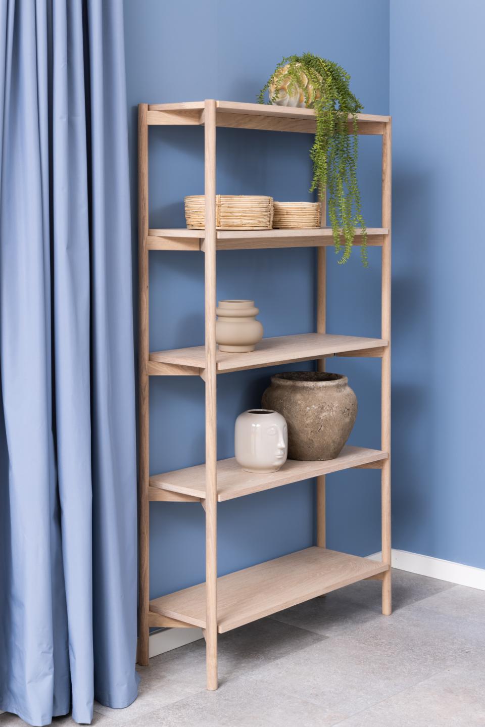 braidwood shelf unit bookcase next to a blue wall and curtain