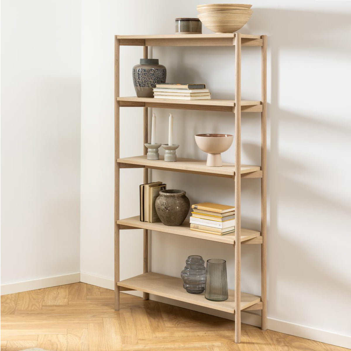 5 tier shelf unit by homestreet filled with homewares next to a white wall and wooden flooring