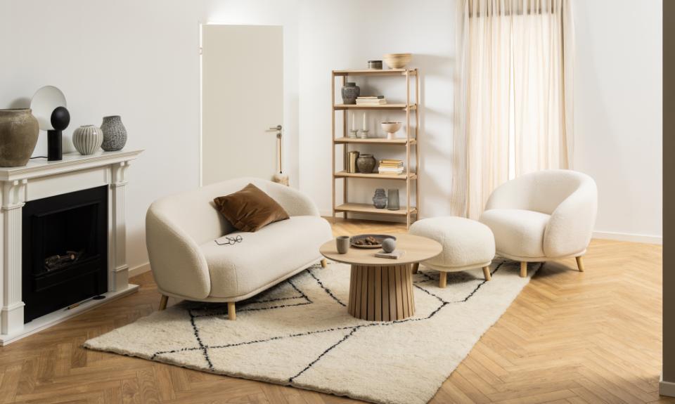 Modern living room with white sofa, wooden coffee table, and bookshelf.