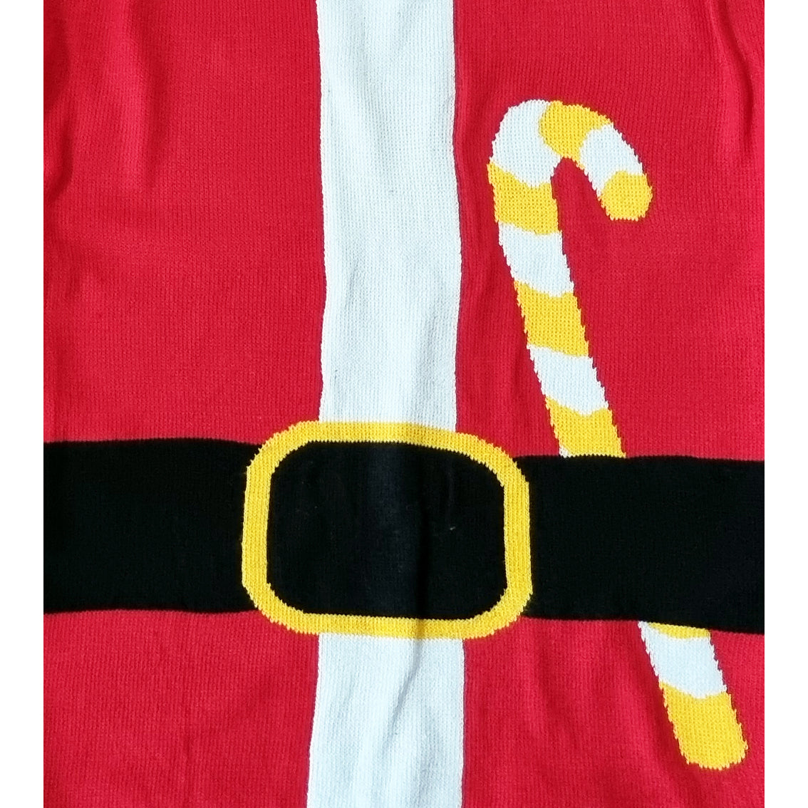 A close-up of a red knit garment featuring a white vertical stripe, a black horizontal belt with a yellow-trimmed buckle, and a yellow-and-white striped candy cane motif.