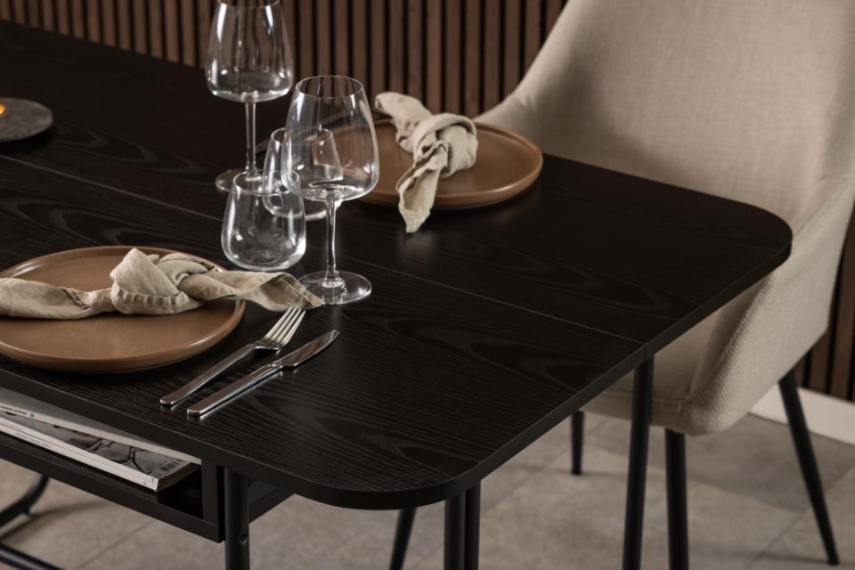 Dining table set with plates, glasses, and cutlery on a dark wooden surface.