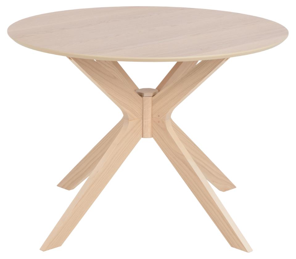 A light natural wood round dining table with a sculptural X-shaped pedestal base, shown on a solid white background.
