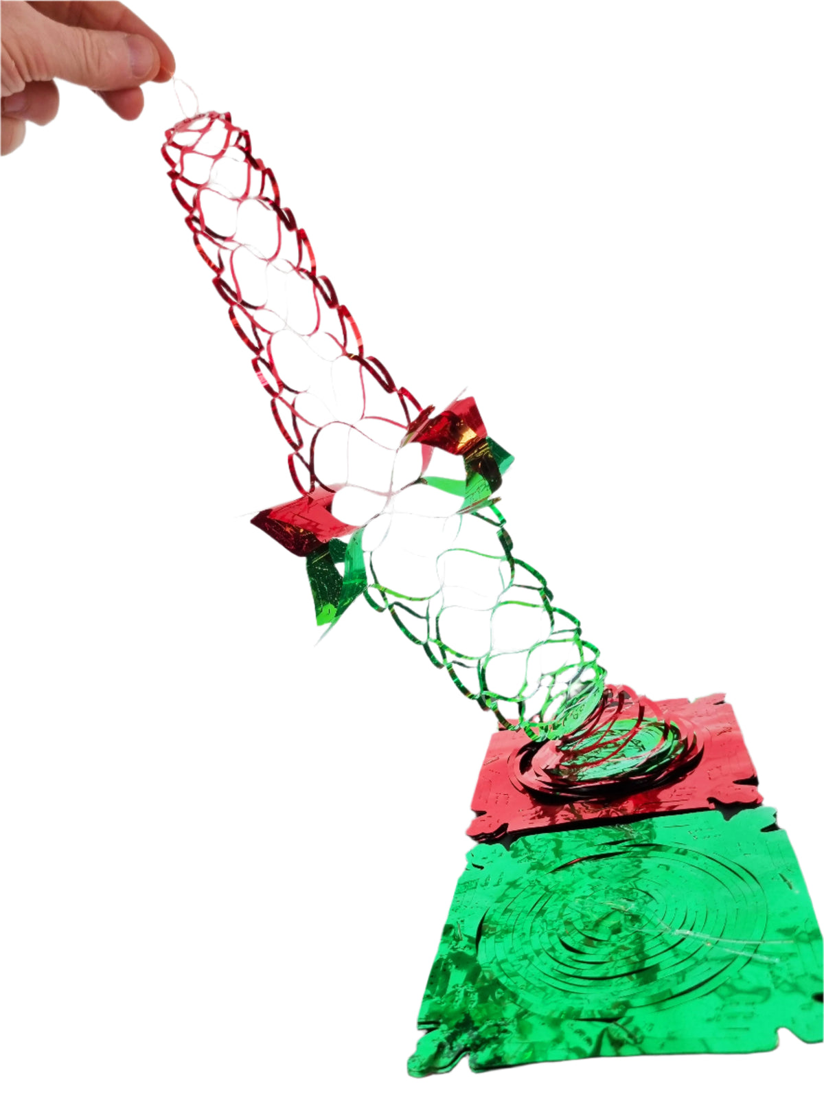 a hand spreading out one of the red and green foil decorations to show how it is opened before use