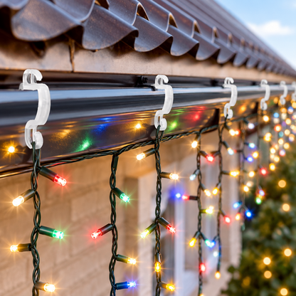 Multicoloured Christmas lights hanging on plastic guttering hooks outside a home