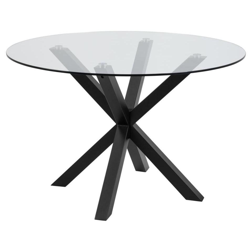 A large round dining table with a clear glass top and a solid matt black metal cross base with angular legs.