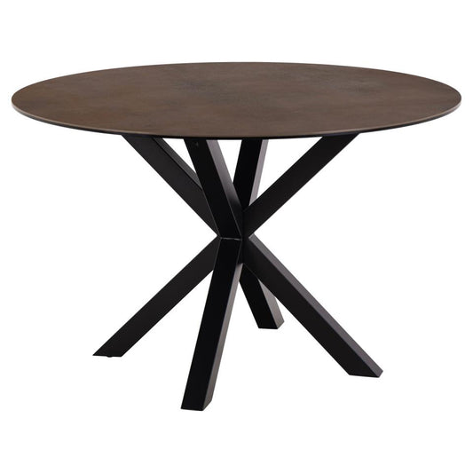 A round dining table with a rusty brown ceramic top and a black powder-coated steel base, displaying a sculptural design.