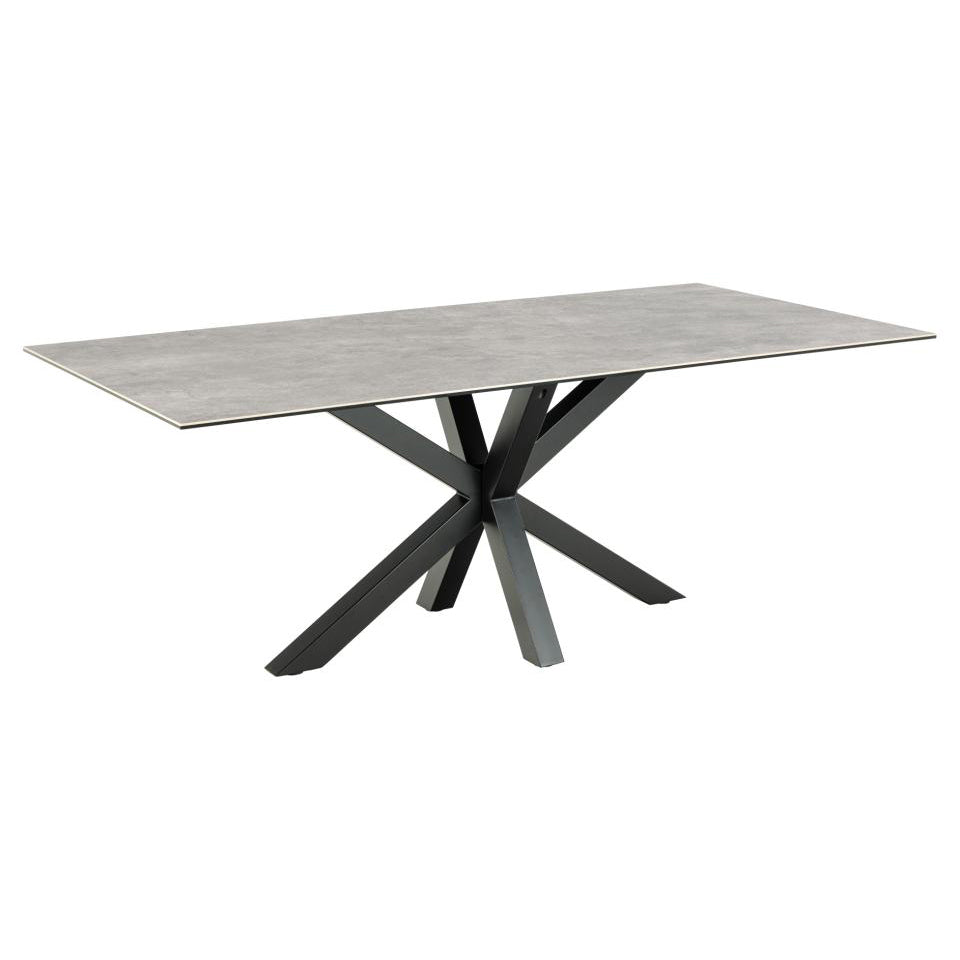 A rectangular grey ceramic dining table with a solid black metal cross base.