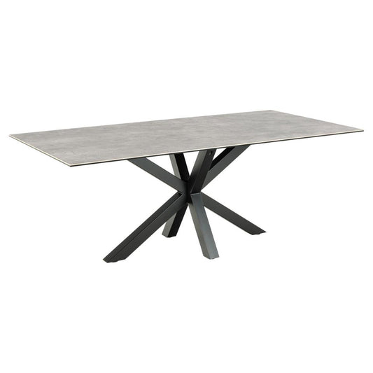A rectangular grey ceramic dining table with a solid black metal cross base.