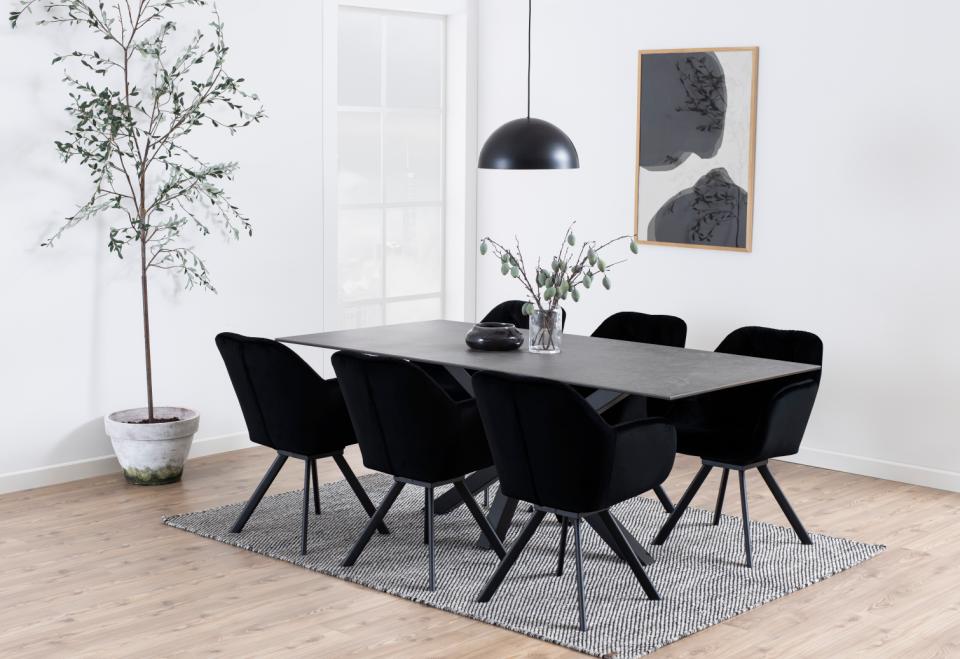 Modern dining room with black table and chairs on a gray rug.