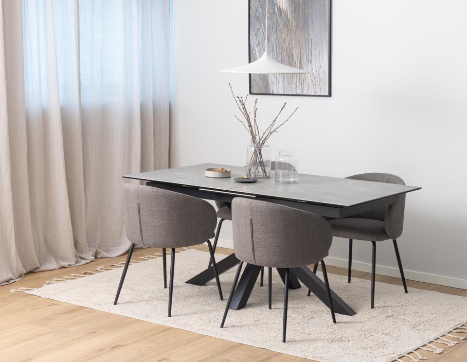 Dining room with a modern table and chairs on a light rug.