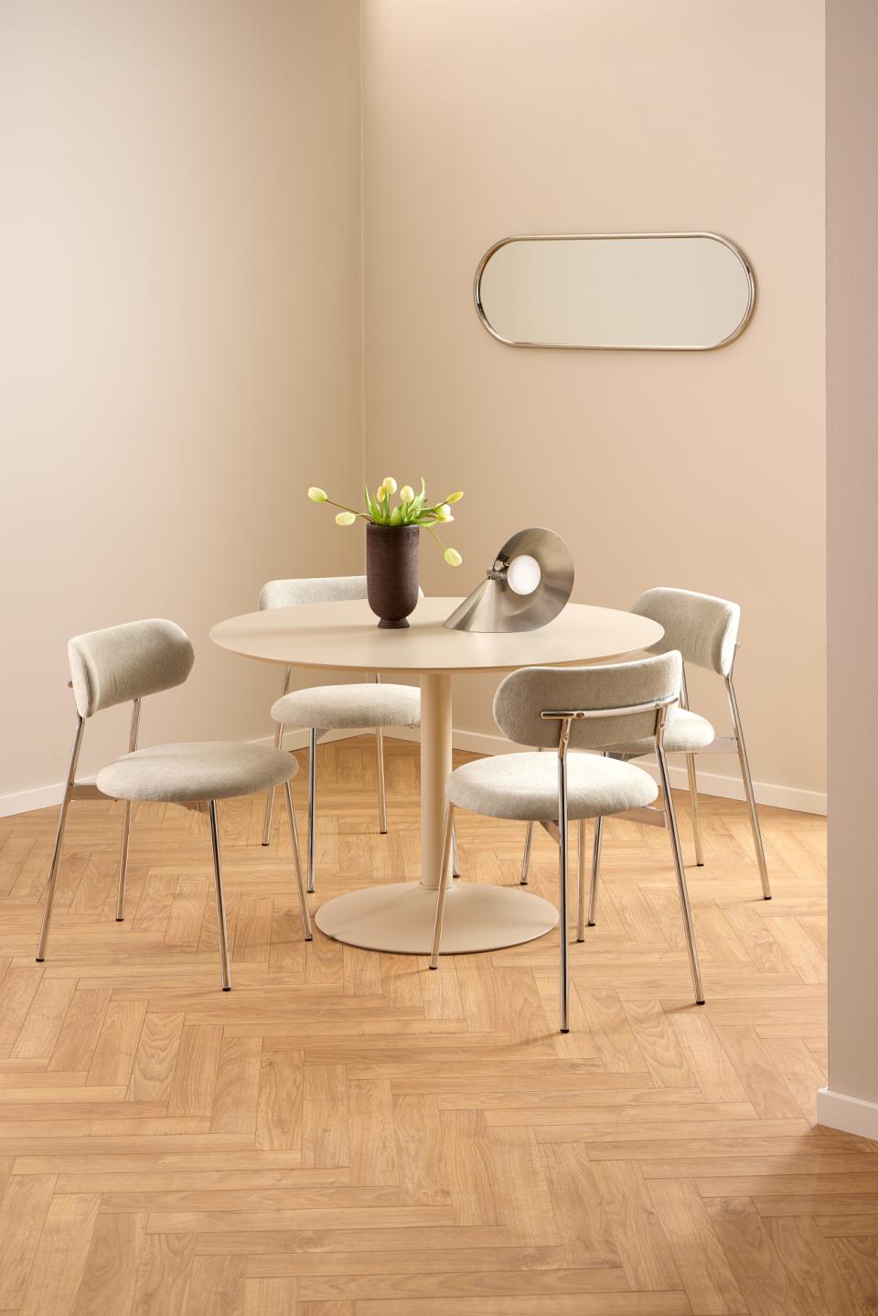 Dining room with a round table and four chairs on a wooden floor.