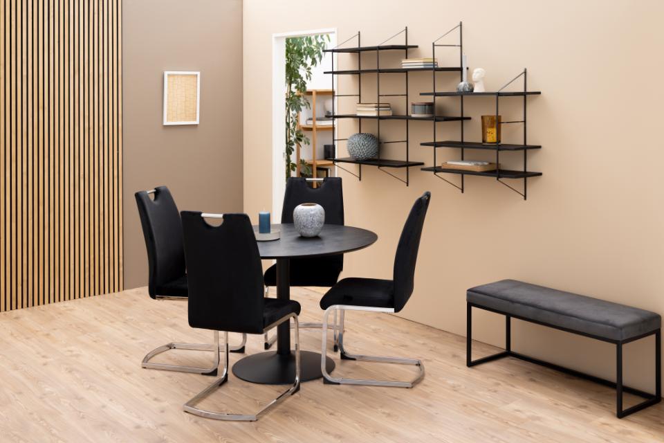 Modern dining area with black chairs, round table, and wall-mounted shelves.