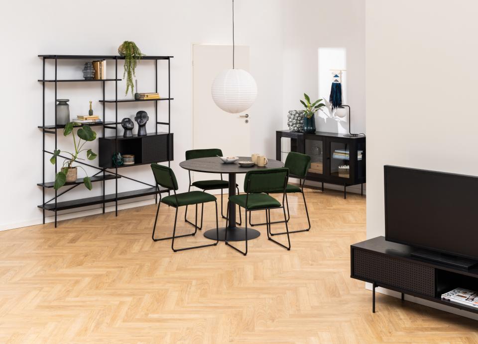 Modern living room with a black dining table and chairs, bookshelf, and TV stand.