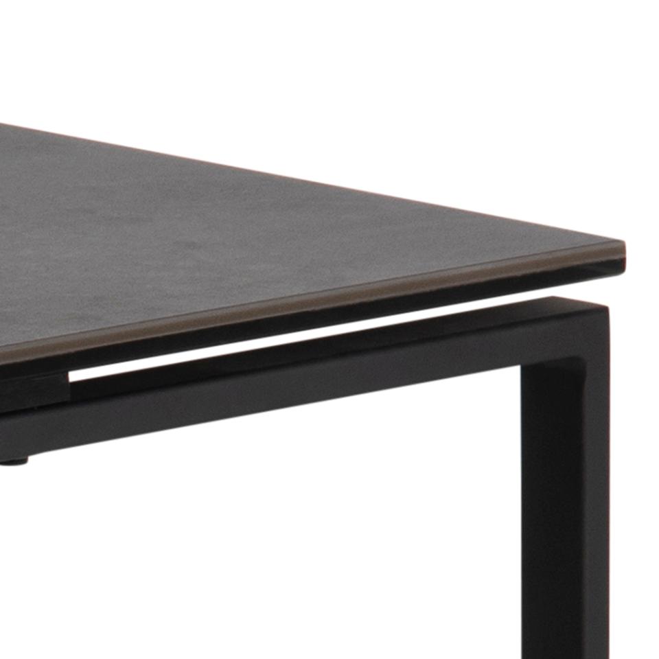 Close-up of a modern table with a dark gray top and black metal legs on a white background