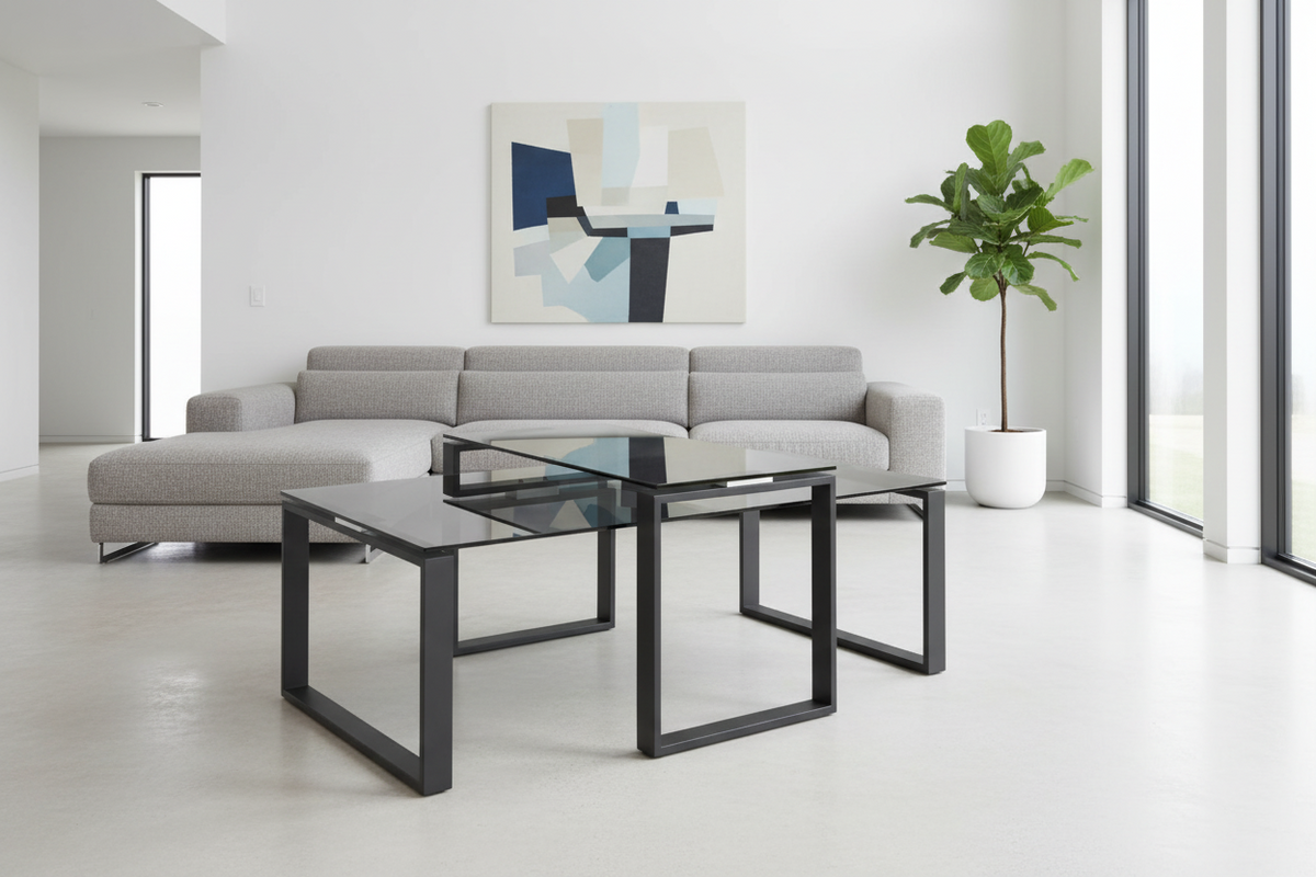 Modern living room with a gray sectional sofa, glass coffee tables, and a plant.