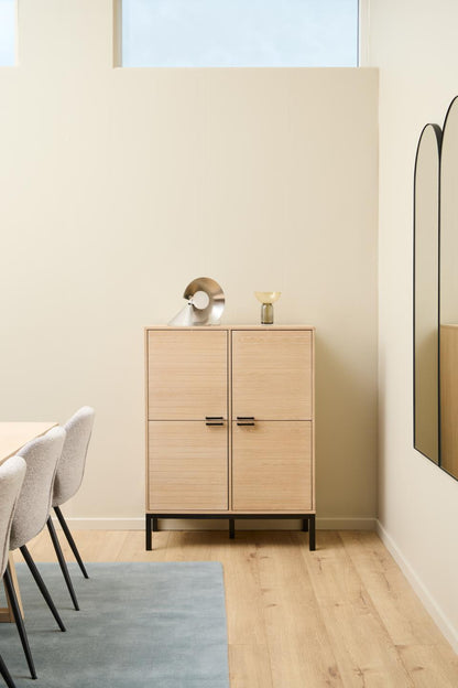 Wooden cabinet with two doors in a room with light-colored walls and wooden flooring.