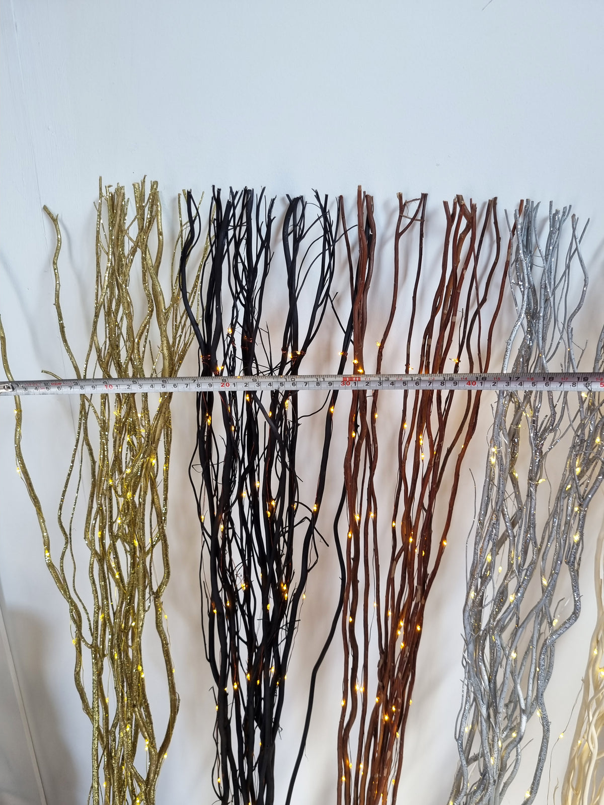 willow twigs with a tape measure across the width on a white background