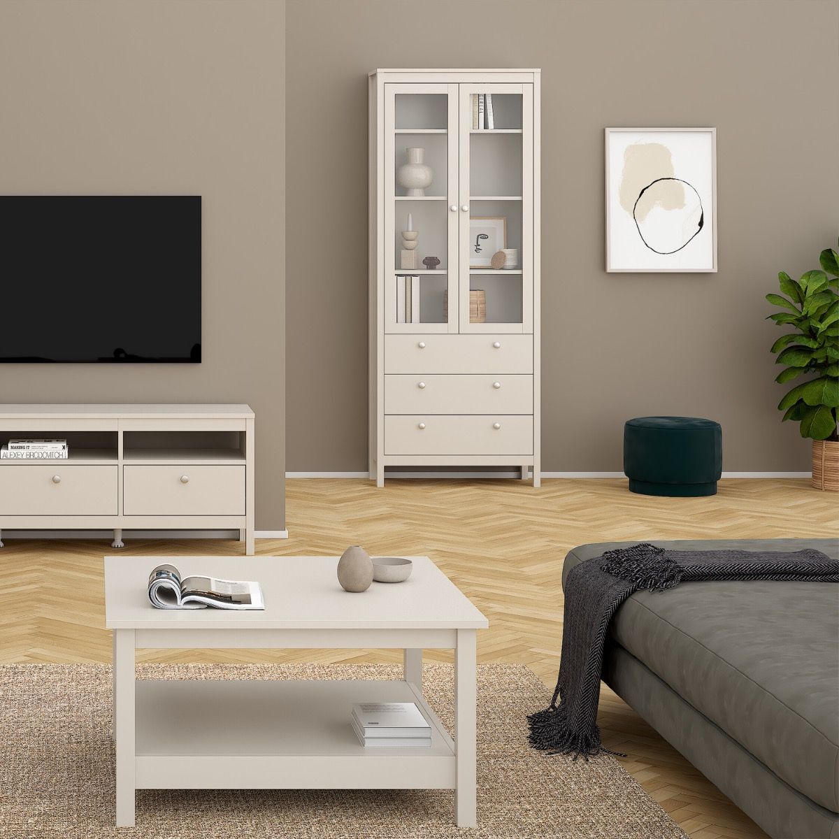 A Madrid cashmere glass display cabinet with two doors, three drawers and three shelves against a wall in a modern home ith matching greige coloured furniture