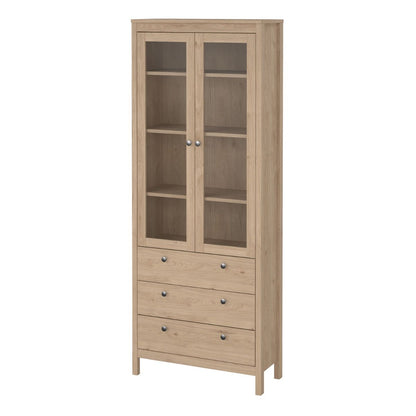 A brown light oak Madrid cabinet with two glass doors, three drawers and three shelves on a white background
