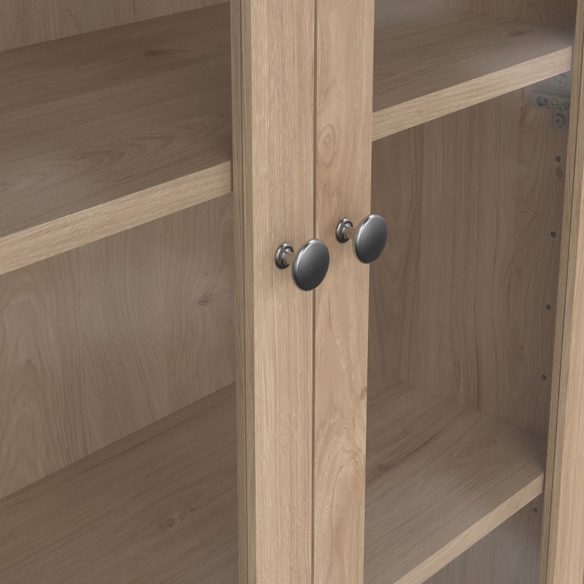 close up view of two glass doors from a light oak cabinet showing two metal handles and inner shelving