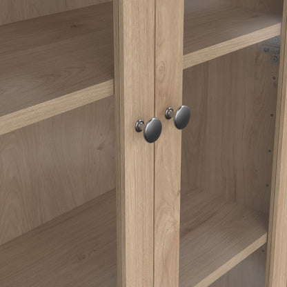 close up view of two glass doors from a light oak cabinet showing two metal handles and inner shelving