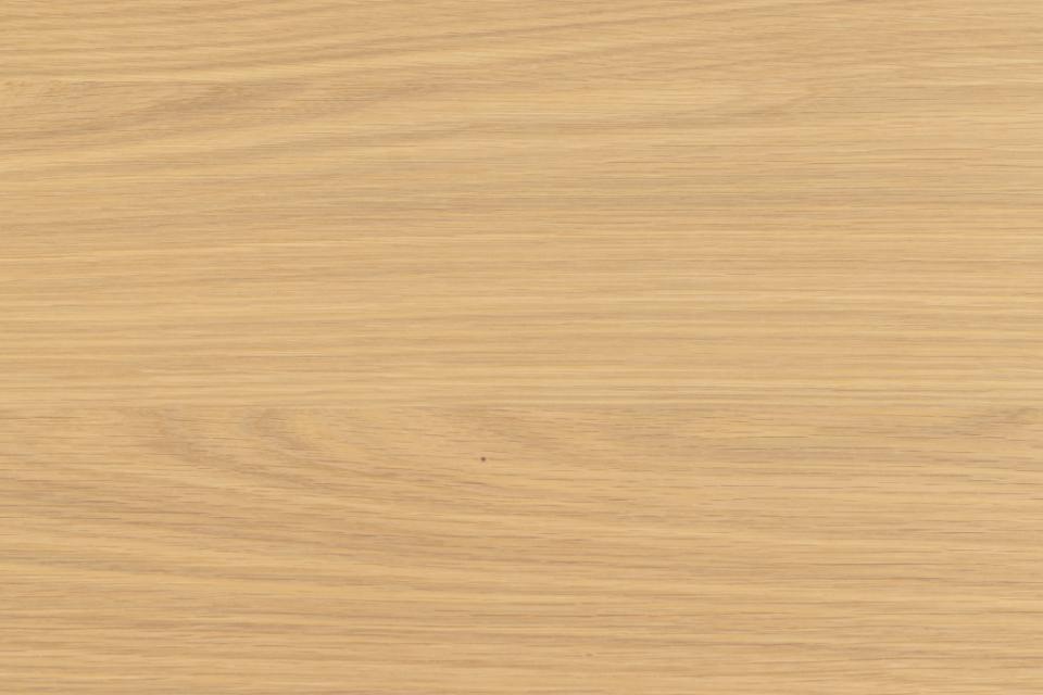 A close-up of a light oak wood grain surface with fine horizontal lines and subtle natural tonal variation.