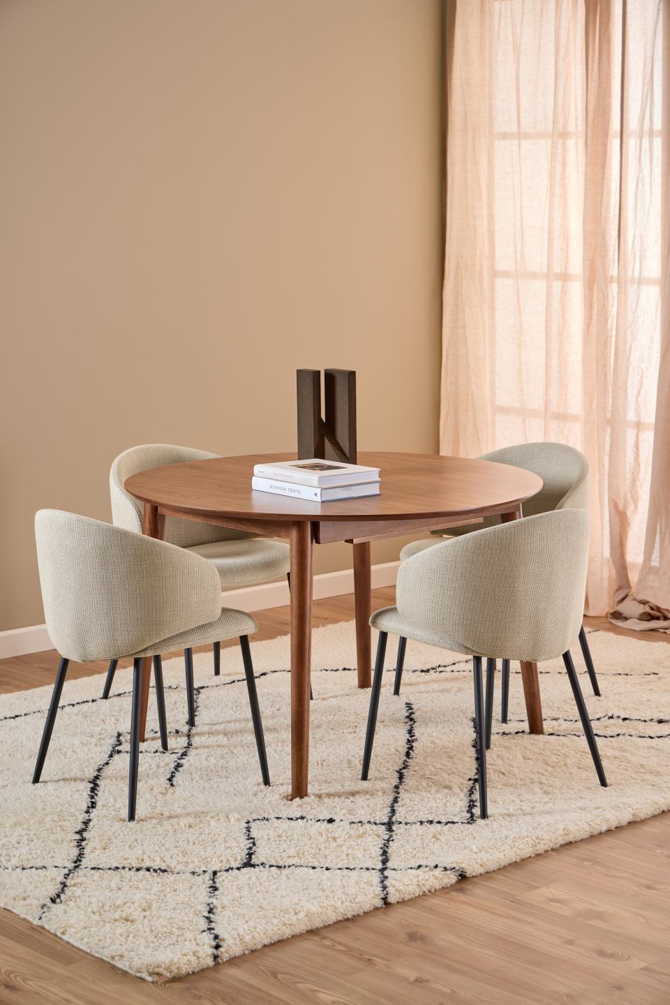 Dining room with a montreux walnut wooden table from Homestreet with four chairs on a patterned rug.