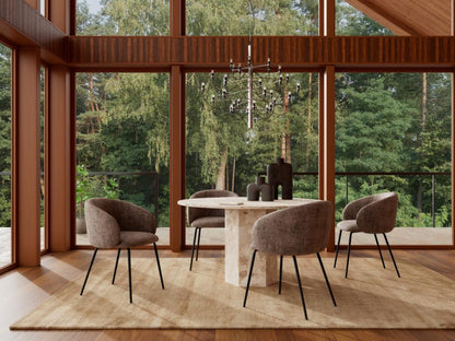 Modern dining room with round table and chairs in a room with large windows overlooking trees.