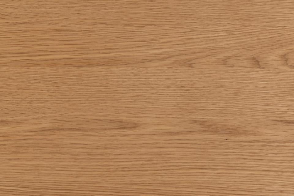 A close-up texture of a light brown wood grain surface with natural horizontal grain patterns.