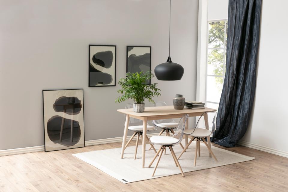 Modern dining room with wooden table, chairs, and abstract art on the wall.