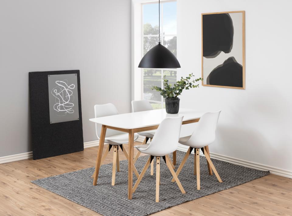 Dining room with a white table and chairs on a gray rug, black pendant light, and abstract art on the walls.