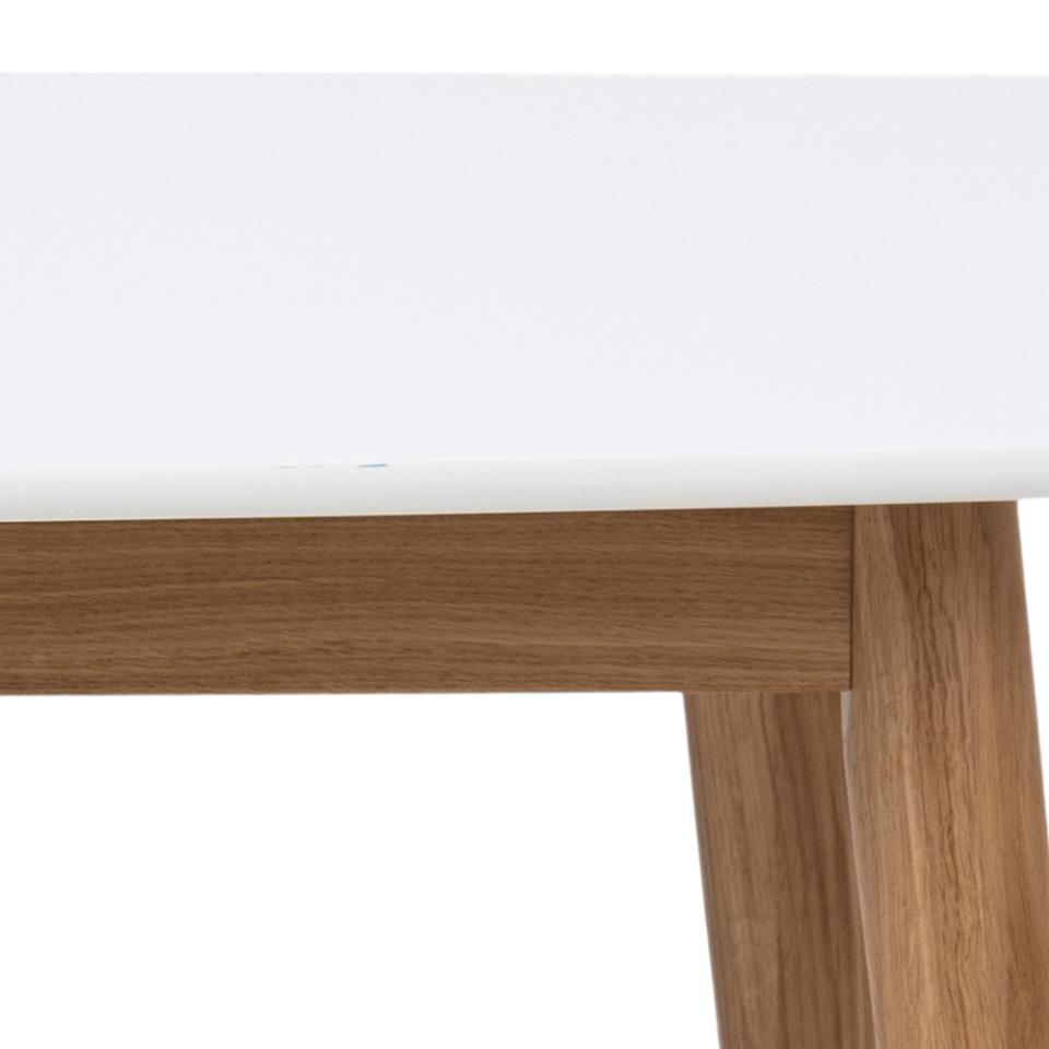 Close-up detail of a table showing a white top edge, a medium brown wood apron, and matching wood legs against a white background.