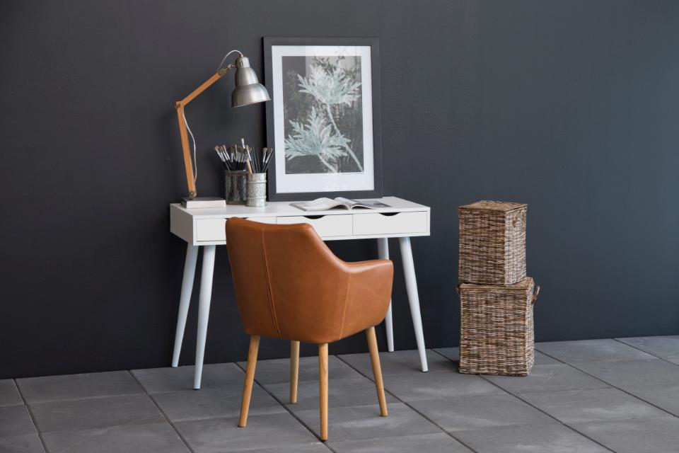 Modern home office with white desk, brown chair, and dark gray walls.