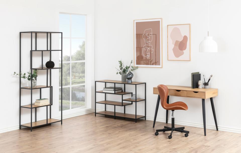 Home office setup with desk, shelves, and chair in a bright room.