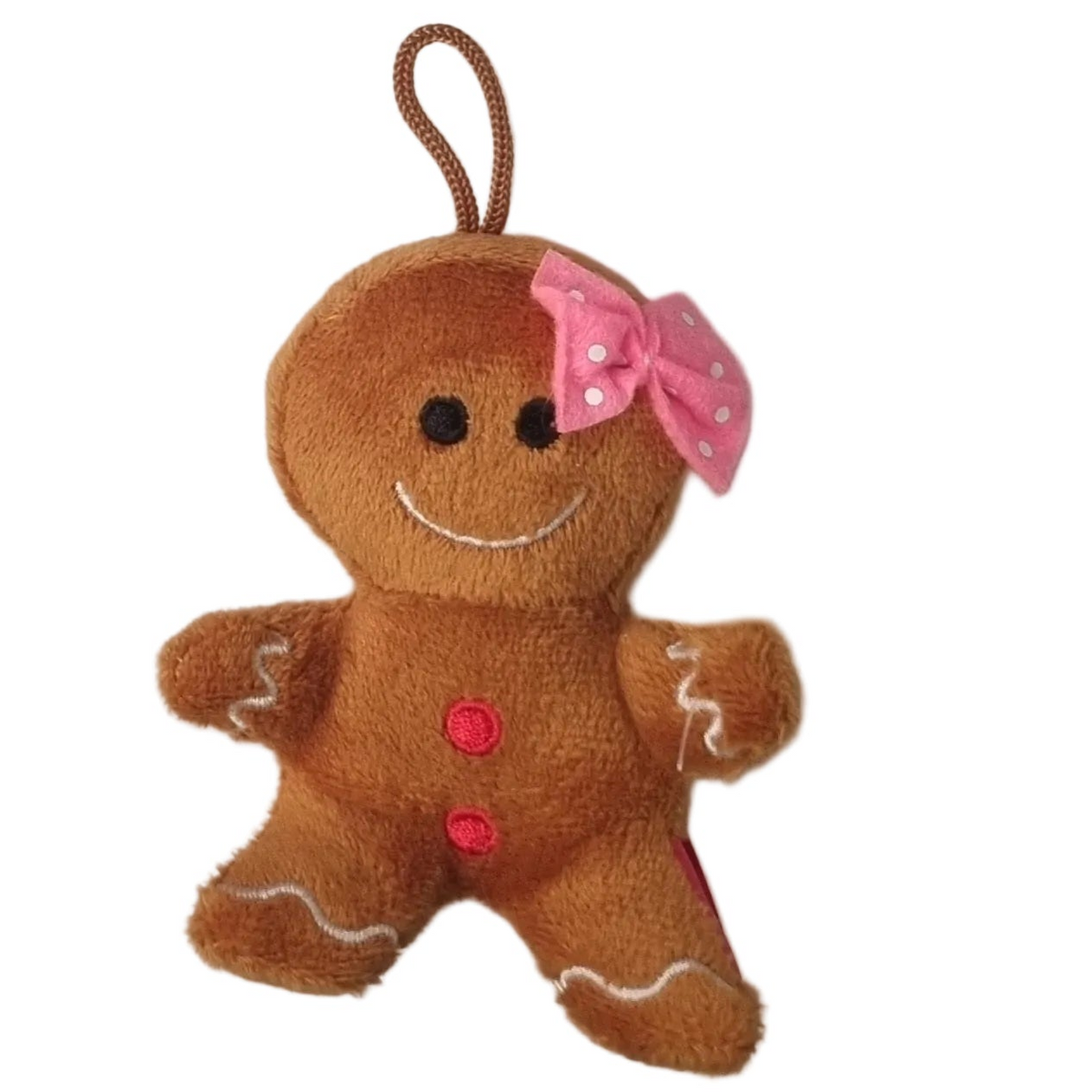 A small gingerbread man plush toy ornament in brown faux fur with a pink polka-dot bow, embroidered smile, and red buttons, shown on a plain white background.