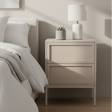 Load image into Gallery viewer, A light beige two-drawer nightstand in a modern bedroom setting, styled with a white table lamp and a small potted succulent on top.
