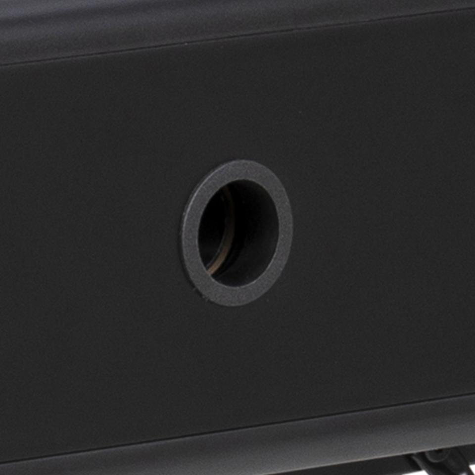 Close-up of a matte black metal surface with a circular mounting hole.