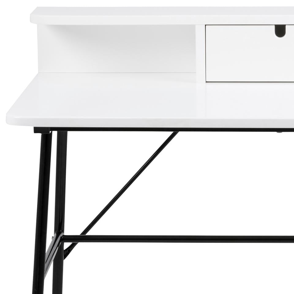 Close-up of a white desk with a single drawer and open shelf, supported by black metal legs and a horizontal support beam.