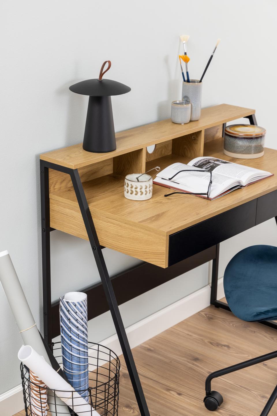 Wooden desk with black metal legs in a room setting