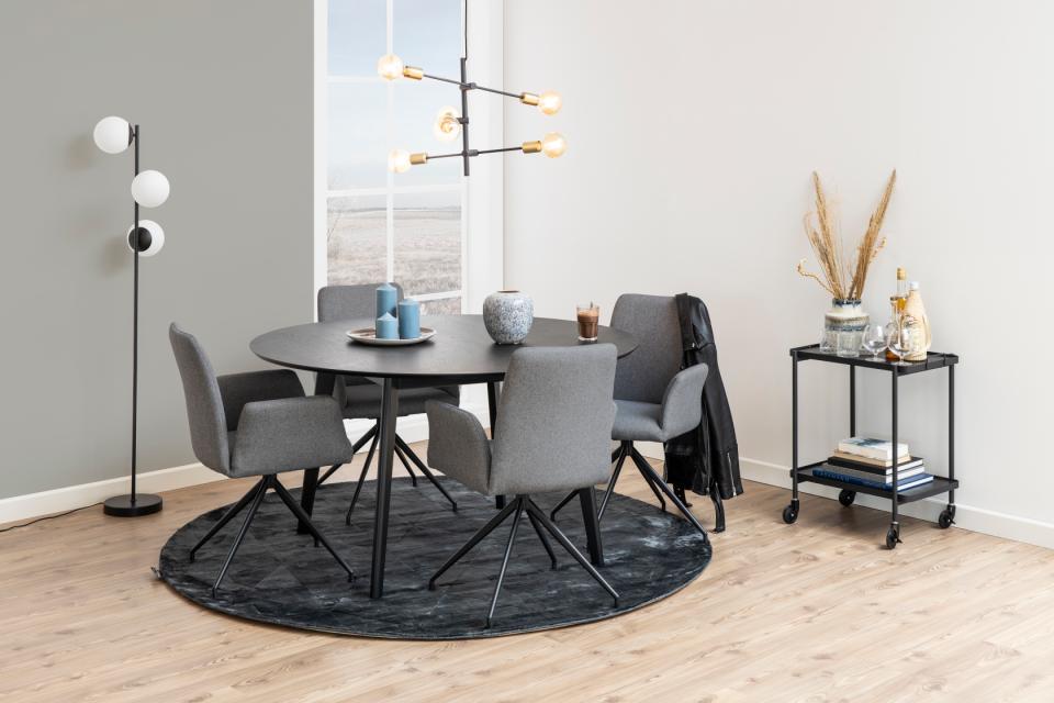 Modern dining room with round table, chairs, and decorative items.
