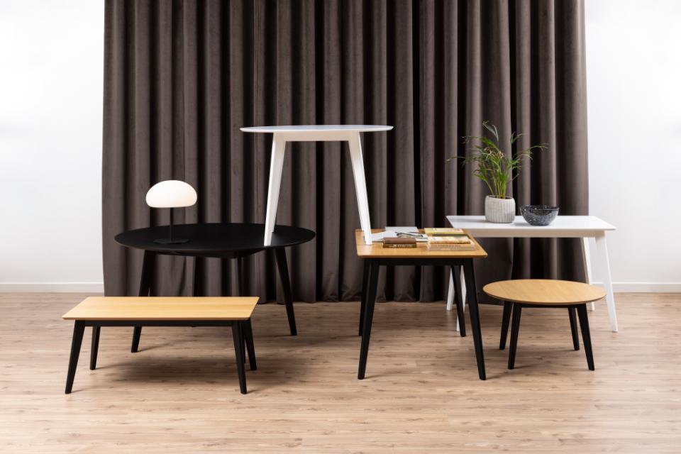 Set of tables and chairs in a room with brown curtains
