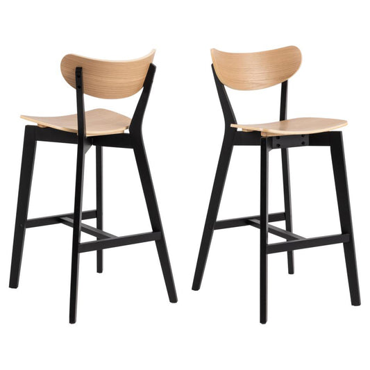 Two Roxby bar stools with curved wood backrests and seats, with black lacquered wooden bases and footrests.