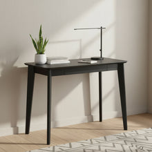 Load image into Gallery viewer, A modern black writing desk with a rectangular top, three front drawers, and four tapered legs, shown on a plain white background.
