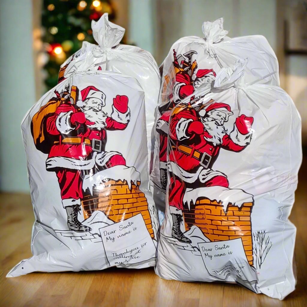Four Santa Claus carrier bags with a Christmas design, featuring space for a recipient's name and decorated with a Santa Claus figure and holiday essentials.