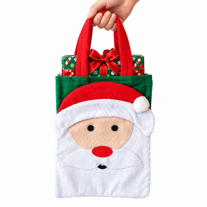 A festive felt Santa Claus gift bag with red handles, held by a hand against a plain white background. The bag features a white face with a red nose, black eyes, and a white beard, with a red Santa hat and a green body.