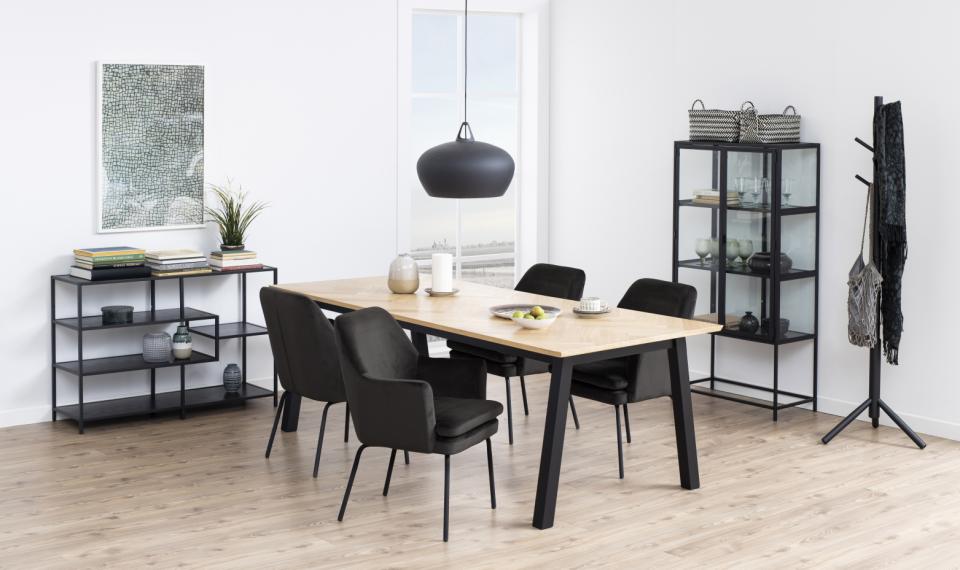 Modern dining room with a wooden table and black chairs in a minimalistic setting.