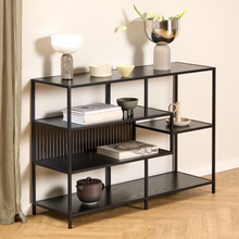 Load image into Gallery viewer, Black shelving unit with decorative items against a beige wall
