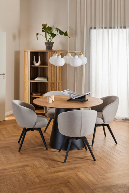 Modern dining area with round Soli table and chairs in a well-lit room.